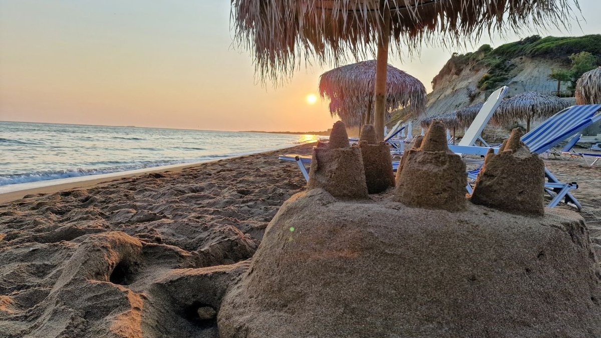 a beach in corfu at sunset