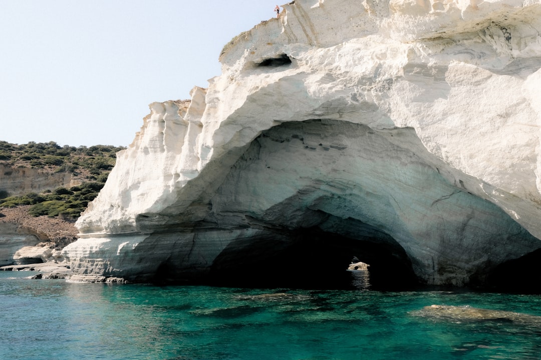 a large white rock formation next to a body of water