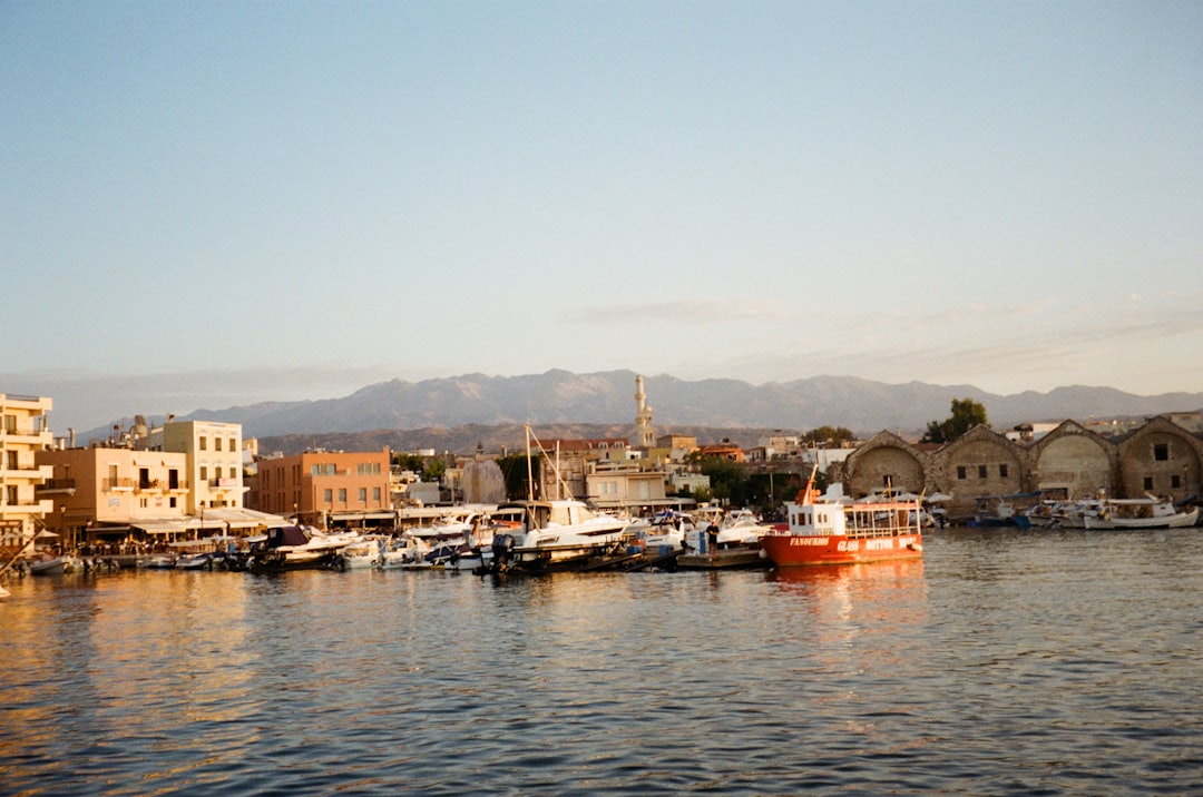red and white boat on body of water near city buildings during daytime
